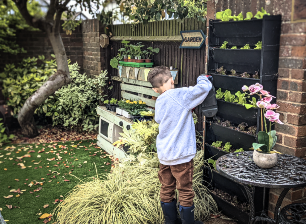 young boy growing his own food in a living wall